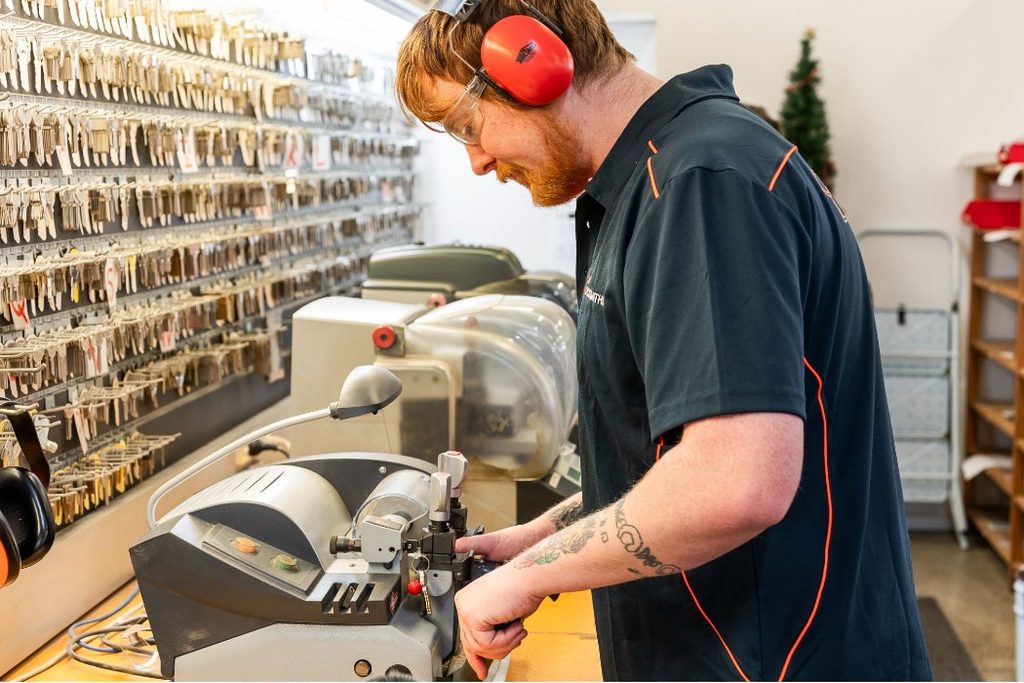 Daniel in City Locksmiths' Newmarket workshop cutting a key